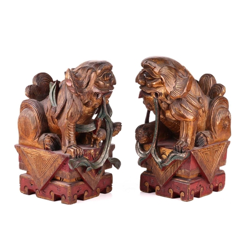 35 - A large pair of Chinese red lacquered and parcel-gilt wood architectural Dog of Foo finials, probabl... 