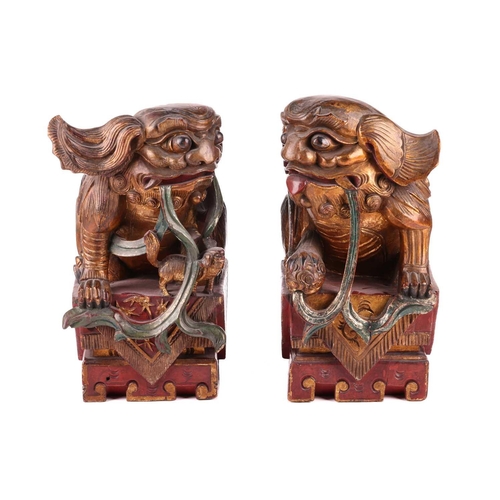 35 - A large pair of Chinese red lacquered and parcel-gilt wood architectural Dog of Foo finials, probabl... 