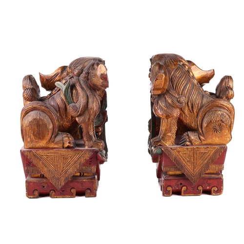 35 - A large pair of Chinese red lacquered and parcel-gilt wood architectural Dog of Foo finials, probabl... 