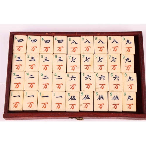 42 - A Chinese rosewood-cased mahjong set with bone and bamboo tiles the sliding door bearing the word Ma... 