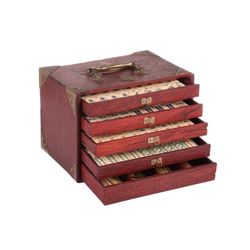 42 - A Chinese rosewood-cased mahjong set with bone and bamboo tiles the sliding door bearing the word Ma... 