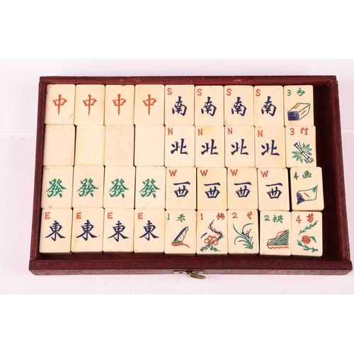 42 - A Chinese rosewood-cased mahjong set with bone and bamboo tiles the sliding door bearing the word Ma... 