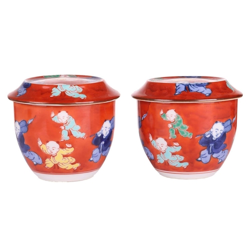 50 - A pair of Chinese Famille Verte porcelain tea bowls and covers, 20th century, painted with coral red... 