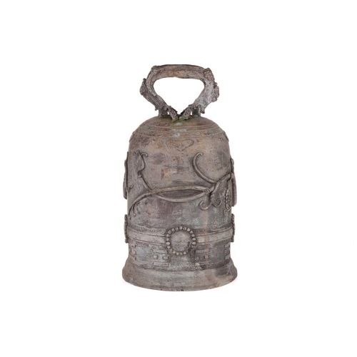 68 - An archaistic Chinese bronze bell with a rustic loop handle the domed body with raised flowering ten... 