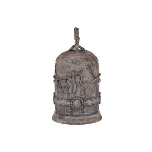 68 - An archaistic Chinese bronze bell with a rustic loop handle the domed body with raised flowering ten... 