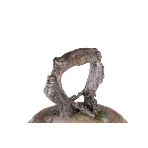 68 - An archaistic Chinese bronze bell with a rustic loop handle the domed body with raised flowering ten... 