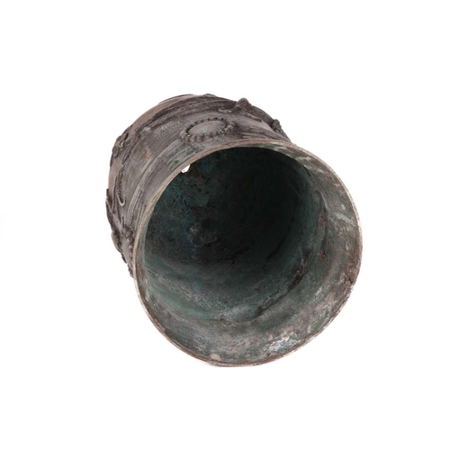 68 - An archaistic Chinese bronze bell with a rustic loop handle the domed body with raised flowering ten... 