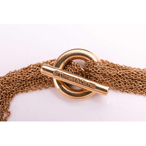 101 - Tiffany & Co. - an 18ct yellow gold multi-strand mesh bracelet with circular charm, consisting of te... 