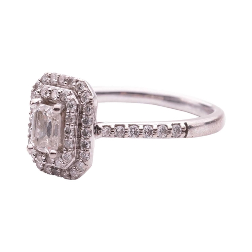 111 - A diamond cluster ring, featuring an emerald cut diamond within a two row border of round brilliant ... 