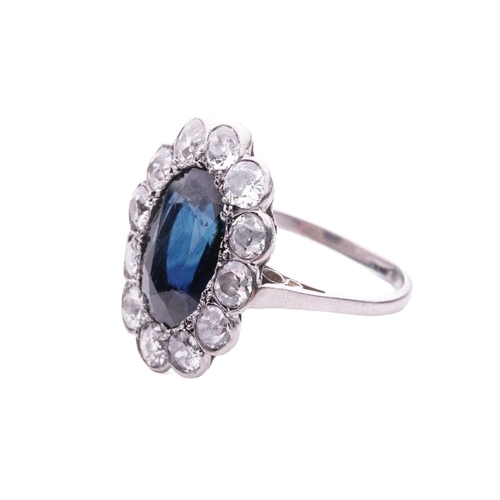 113 - A sapphire and diamond cluster ring, circa 1920s, featuring an oval green-blue sapphire measuring 12... 