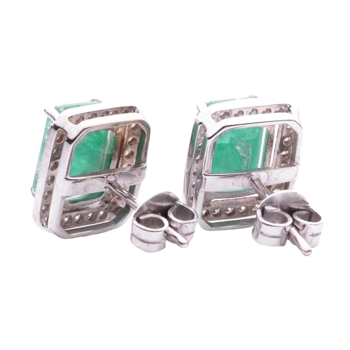 114 - A pair of emerald and diamond cluster earrings, each consisting of an octagonal step-cut emerald app... 