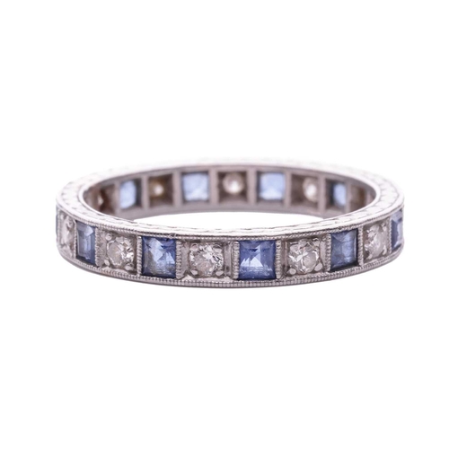 128 - A sapphire and diamond eternity ring, alternating with square table-cut sapphires and transitional-c... 