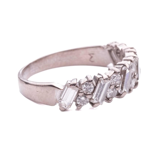 133 - A half-eternity diamond-set ring, claw set with pairs of round brilliant diamonds between baguette-c... 