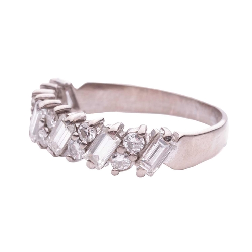 133 - A half-eternity diamond-set ring, claw set with pairs of round brilliant diamonds between baguette-c... 