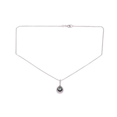 134 - A tsavorite garnet, onyx and diamond pendant, the drop shape pendant set to the centre with a pear-s... 