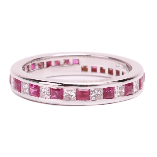 139 - A ruby and diamond eternity ring, set with a continuous row of alternating square step cut synthetic... 