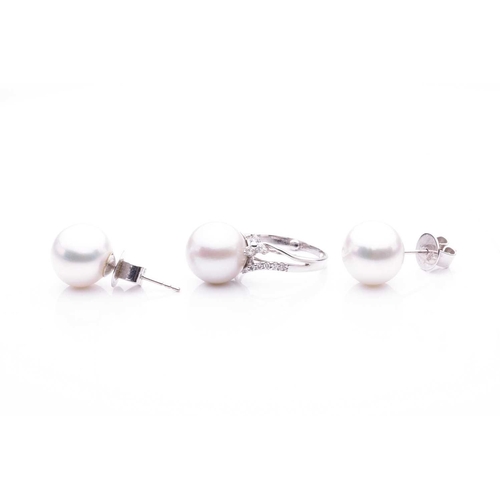 143 - A cultured saltwater pearl dress ring and a pair of stud earrings; the dress ring features a large a... 