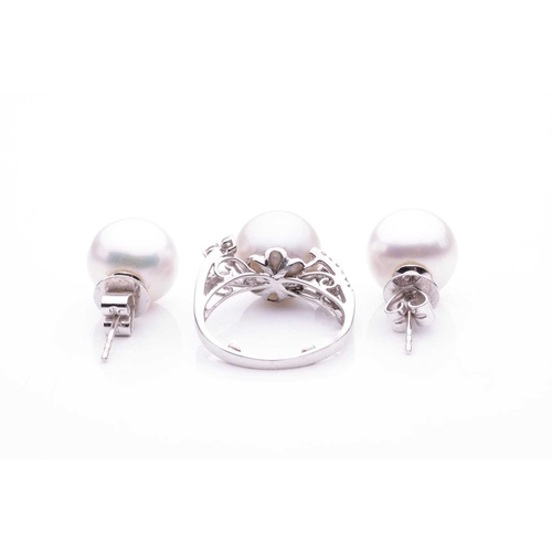 143 - A cultured saltwater pearl dress ring and a pair of stud earrings; the dress ring features a large a... 