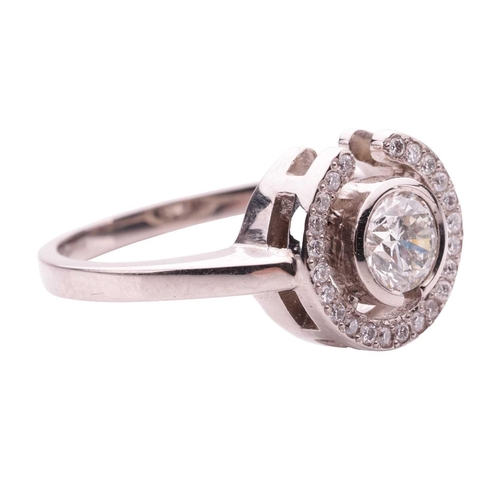 154 - A diamond halo ring, collet-set with a round brilliant-cut diamond of 0.50ct, encircled with a frame... 