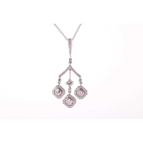 160 - A diamond pendant in a chandelier design with a triple drop, each drop featuring a square emerald cu... 