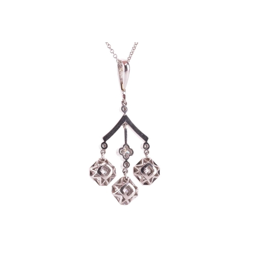 160 - A diamond pendant in a chandelier design with a triple drop, each drop featuring a square emerald cu... 