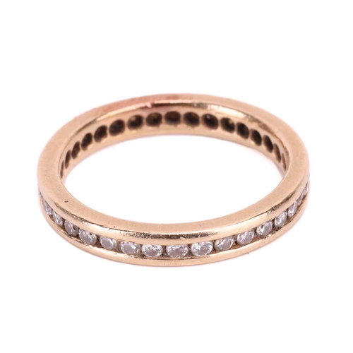 177 - A diamond eternity ring, channel-set with an array of brilliant-cut diamonds in a flat-edged band, w... 