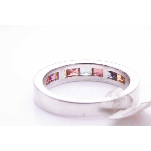 184 - A gem-set half hoop eternity ring. Set with nine vari-coloured sapphires and spinel within a white g... 