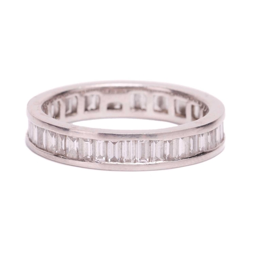 191 - A baguette cut diamond eternity ring, set with a contiuous row of baguette cut diamonds in a channel... 