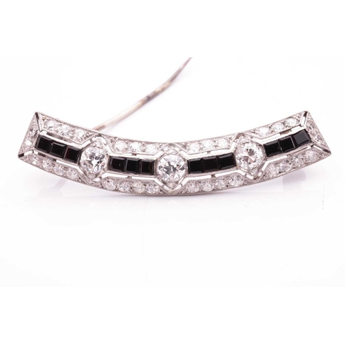 198 - An Art Deco diamond and onyx brooch, of a bevelled curved form, containing three old-European cut di... 