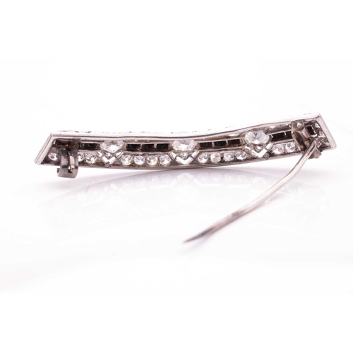 198 - An Art Deco diamond and onyx brooch, of a bevelled curved form, containing three old-European cut di... 