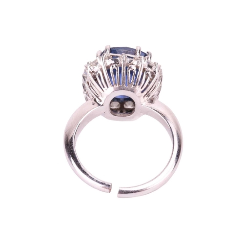 199 - A Ceylon sapphire and diamond cluster ring, featuring a cushion mixed-cut sapphire of intense blue c... 