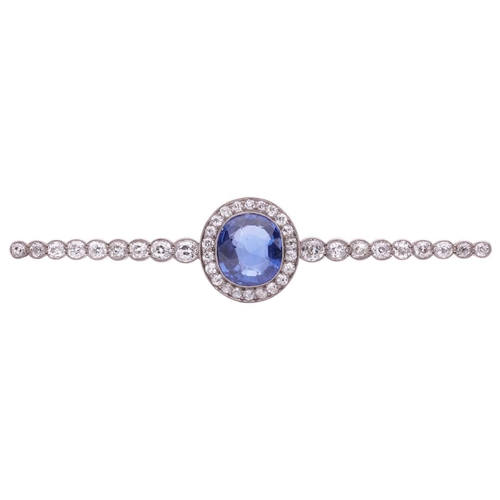 201 - An Art Deco sapphire and diamond set bar brooch, featuring a mixed oval cut sapphire of bright blue ... 