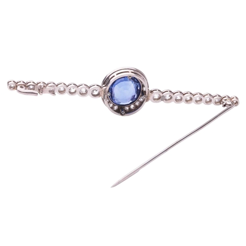 201 - An Art Deco sapphire and diamond set bar brooch, featuring a mixed oval cut sapphire of bright blue ... 