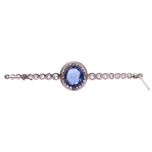 201 - An Art Deco sapphire and diamond set bar brooch, featuring a mixed oval cut sapphire of bright blue ... 