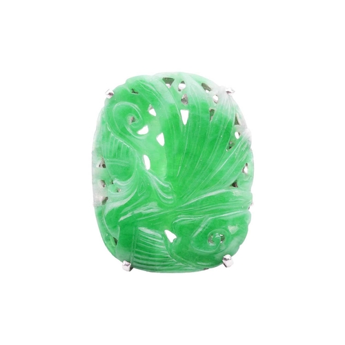 206 - An Art Deco carved jadeite dress ring, circa 1900s, the cushion-shaped jade panel depicting a Chines... 