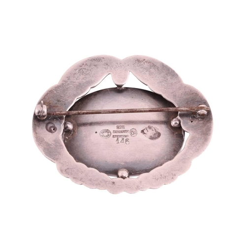 210 - Georg Jensen - an oval foliate brooch, centred with an oval empty cartouche within a repoussé surrou... 