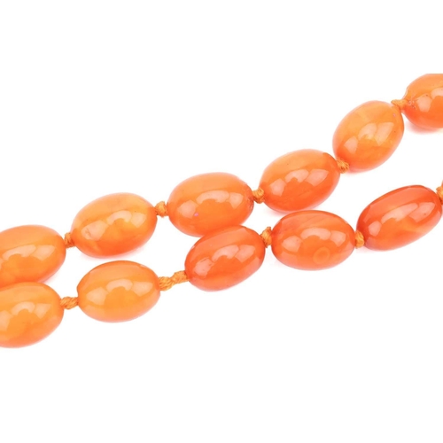 24 - A butterscotch oval amber bead necklace, featuring hand-knotted graduated oval amber beads from 10.2... 