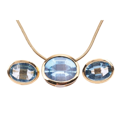 26 - A Swiss blue topaz pendant and earring suite, each oval gemstone bezel-set in yellow mounts tested a... 