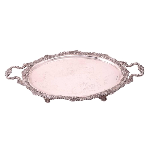 296 - An Edwardian silver two handled tray, oval with cast foliate border and shell mounted foliate side h... 