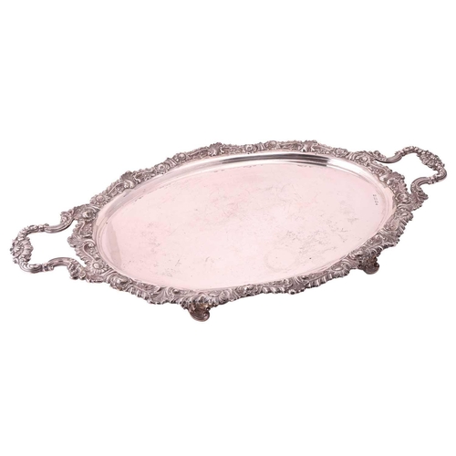 296 - An Edwardian silver two handled tray, oval with cast foliate border and shell mounted foliate side h... 