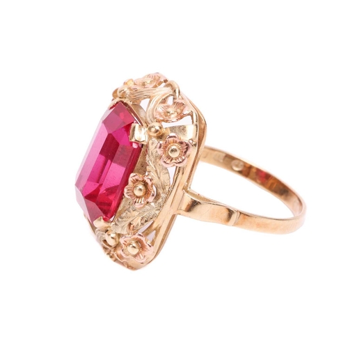 30 - A synthetic ruby dress ring, centred with an octagonal-cut synthetic ruby within an intricately embo... 