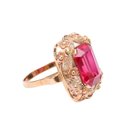 30 - A synthetic ruby dress ring, centred with an octagonal-cut synthetic ruby within an intricately embo... 