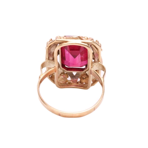 30 - A synthetic ruby dress ring, centred with an octagonal-cut synthetic ruby within an intricately embo... 