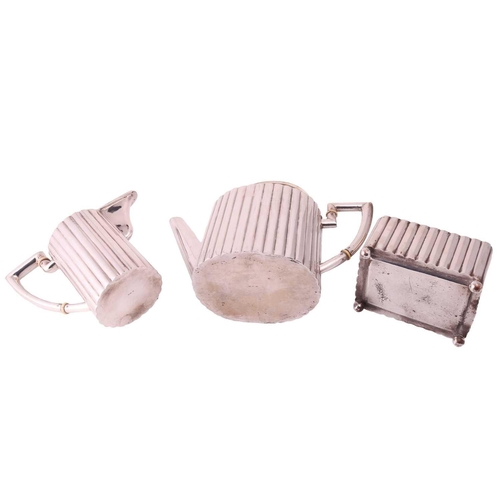 319 - An Art Deco three-piece tea service, comprising a tea pot of oval form with reeded body, the hinged ... 