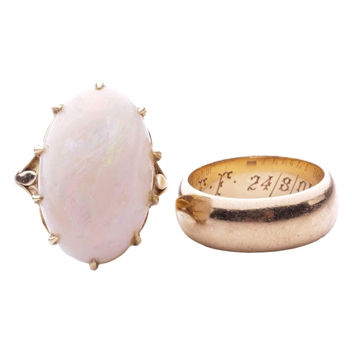 35 - A white opal single stone ring and a wedding band; the opal ring set with an oval white opal measuri... 