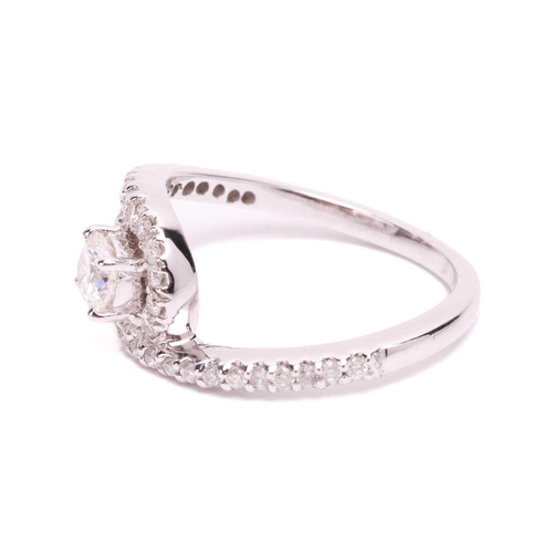 38 - A diamond halo twist ring, the principle round brilliant diamond measuring approximately 4.4mm, with... 