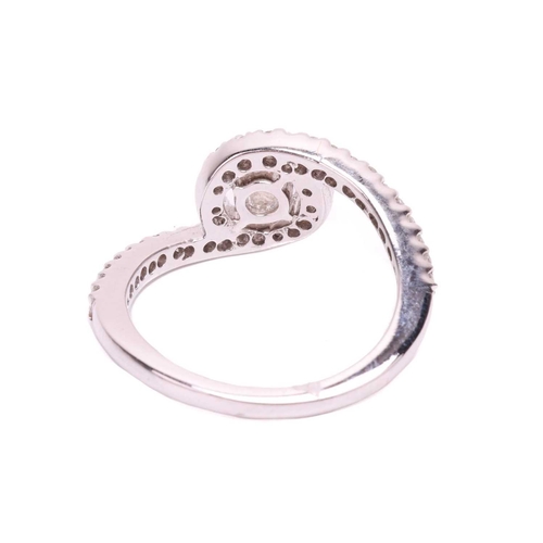 38 - A diamond halo twist ring, the principle round brilliant diamond measuring approximately 4.4mm, with... 