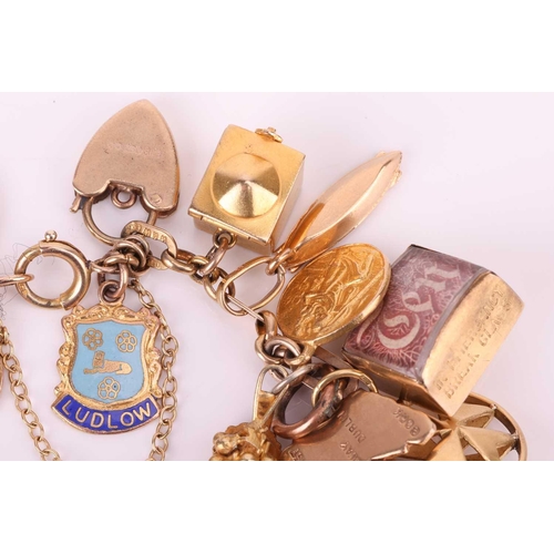 52 - A charm bracelet in 9ct gold, with a variety of charms including two half sovereigns; Edward VII, 19... 