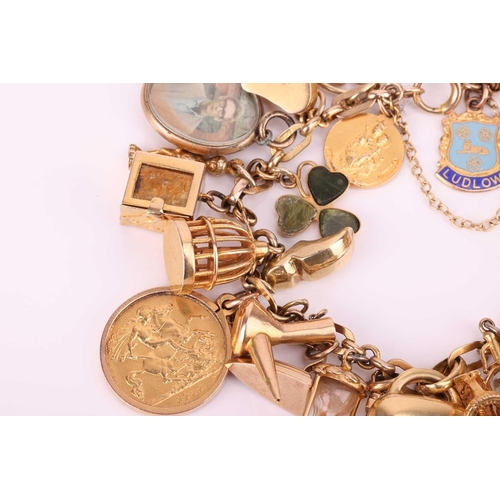 52 - A charm bracelet in 9ct gold, with a variety of charms including two half sovereigns; Edward VII, 19... 