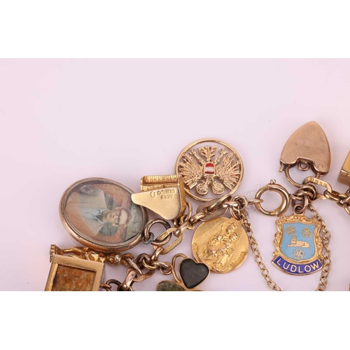 52 - A charm bracelet in 9ct gold, with a variety of charms including two half sovereigns; Edward VII, 19... 